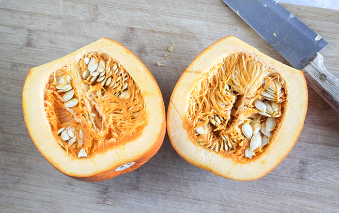 a pumpkin cut in half with a knife on the side