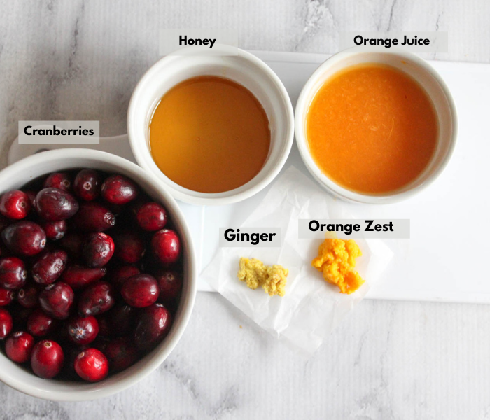 cranberry sauce ingredients left to right Cranberries, honey, orange juice, grated orange zest, grated ginger.