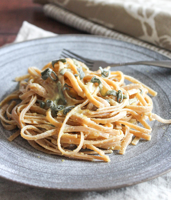 linguine pasta with pumpkin sage sauce on a blue plate.