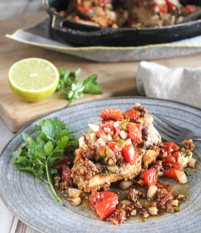 Salsa chicken on a plate with cilantro and a fork