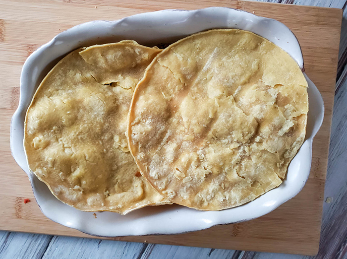 tortillas on top of chicken casserole in a baking dish