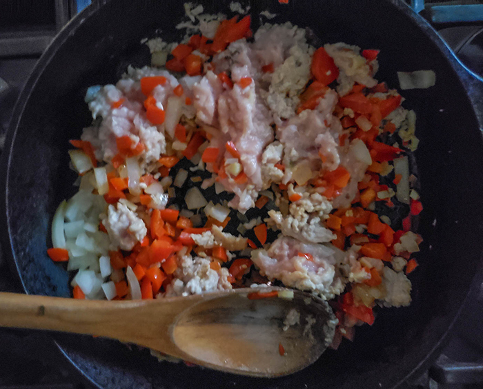 peppers and ground chicken cooking in a skillet