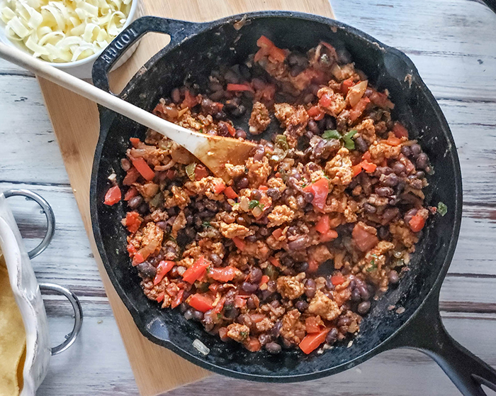 chicken peppers and tomatoes mixed together in a skillet