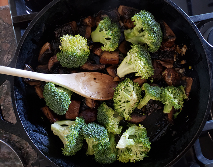 Cooked Portobello mushrooms and broccoli in a skilet