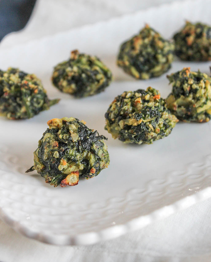 a close up view of baked spinach balls on a white plate