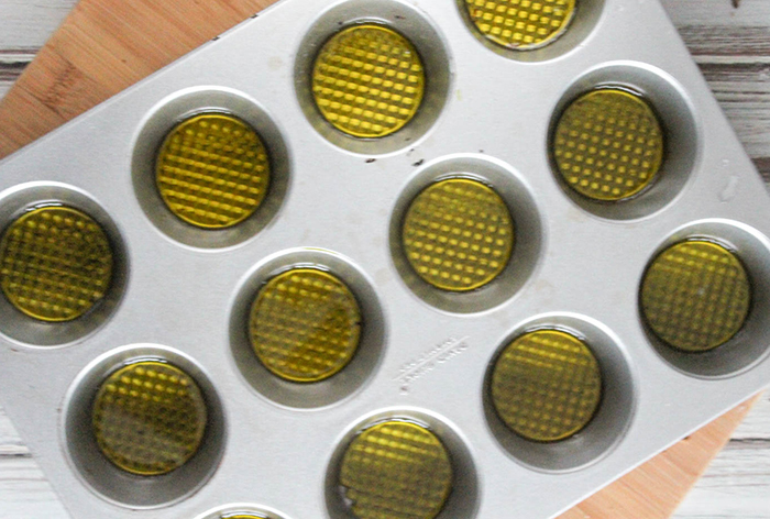 an overhead view of muffin pan with oil in it