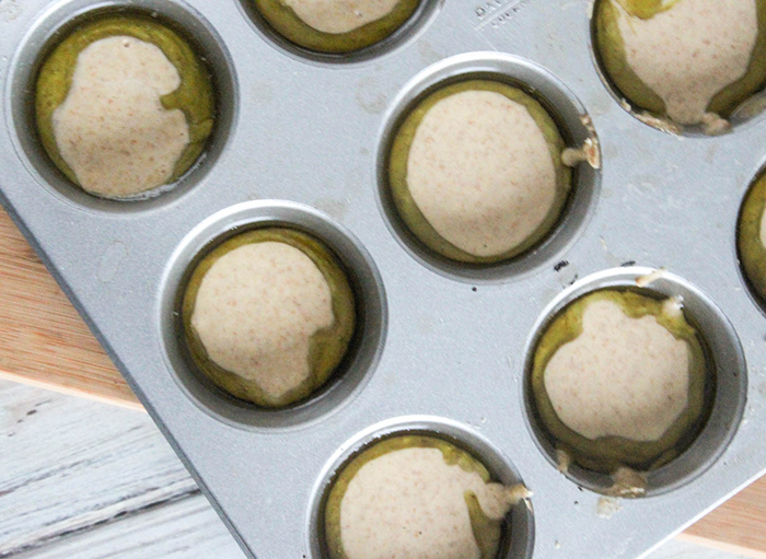 an overhead view of batter poured into hot oil in muffin pan