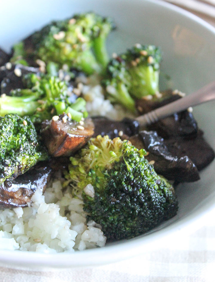 a close up of broccoli and mushrooms in a dish