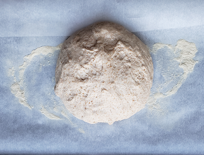 the dough formed into a ball on white parchment paper