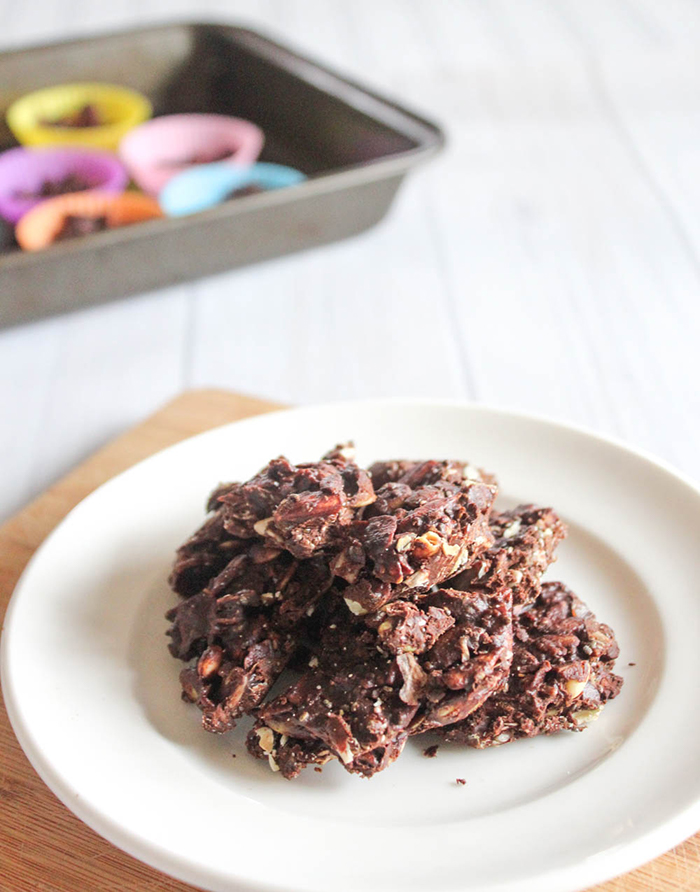 almond clusters in dark chocolate on a white plate