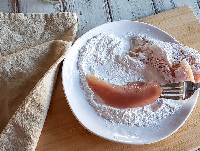 chicken tenders dipping into flour