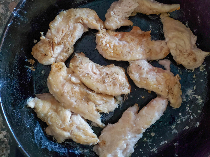 chicken tenders cooking in a skillet