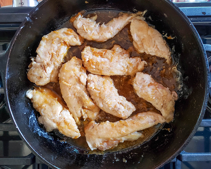 chicken tenders cooking in a skillet 