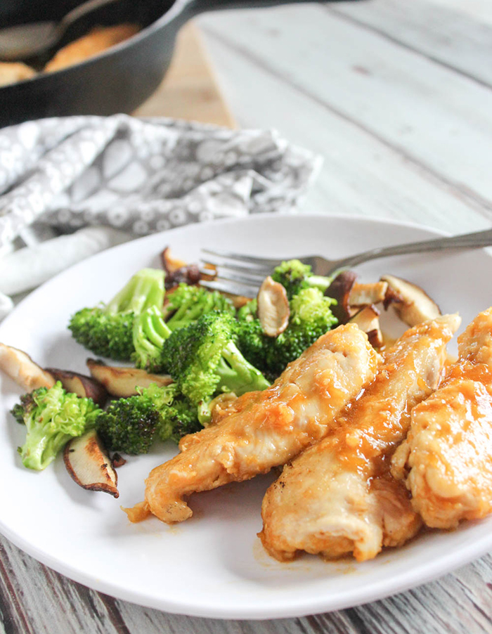 healthy orange chicken on a plate with broccoli and mushrooms