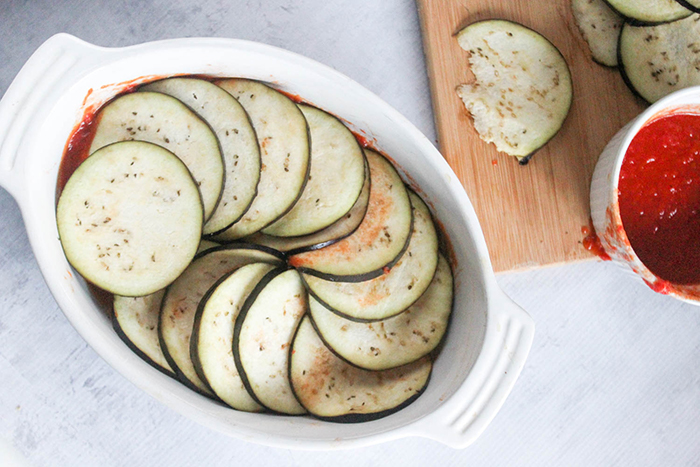 eggplant slices arranged in a casserole dish on top of sauce