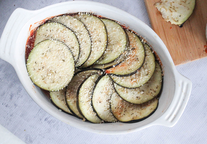 overhead view of eggplant slices in casserole with bread crumbs on top