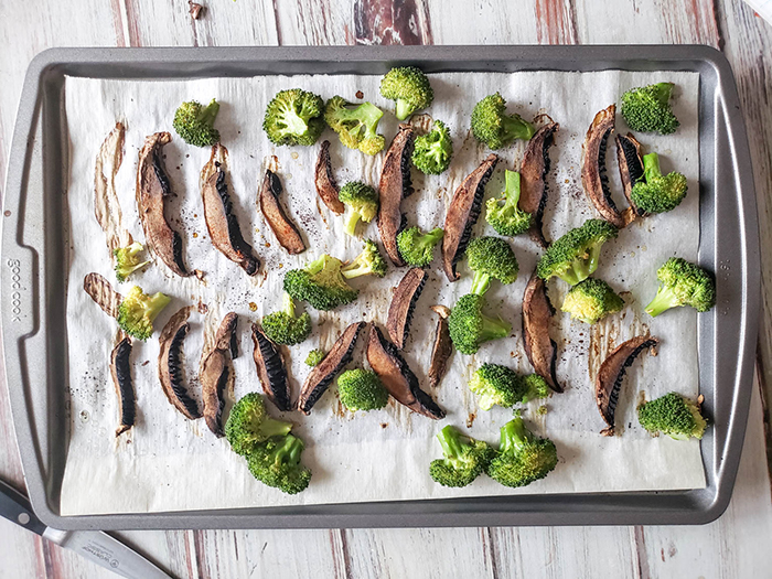 sliced portobello mushrooms and broccoli on a baking sheet