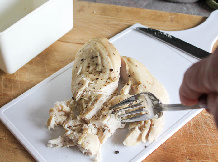 a picture of 2 forks shredding chicken