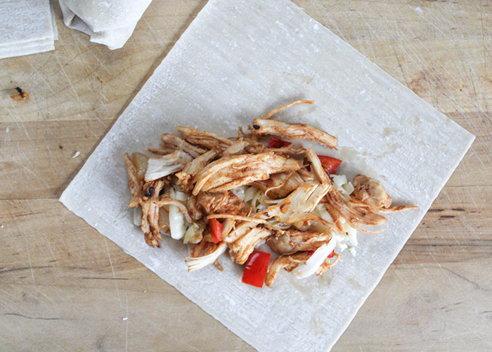 shredded chicken and veggies on an egg roll wrappter