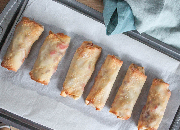 baked and golden egg rolls on a baking sheet