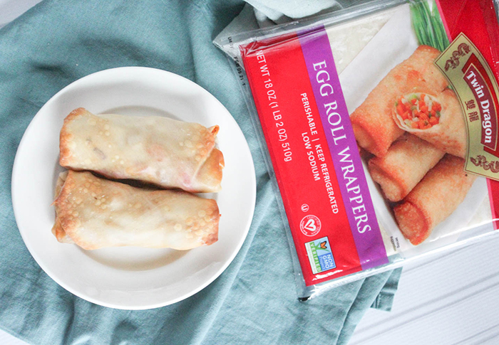 an overhead view of bbq chicken egg rolls on a plate with the twin dragon packgaging on the side