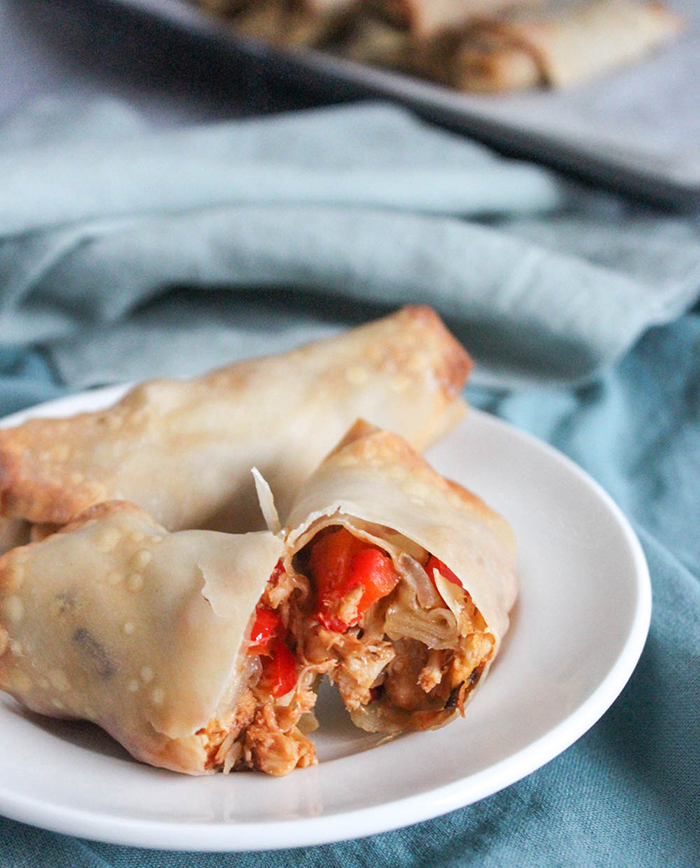 a bbq egg roll cut in half on a plate