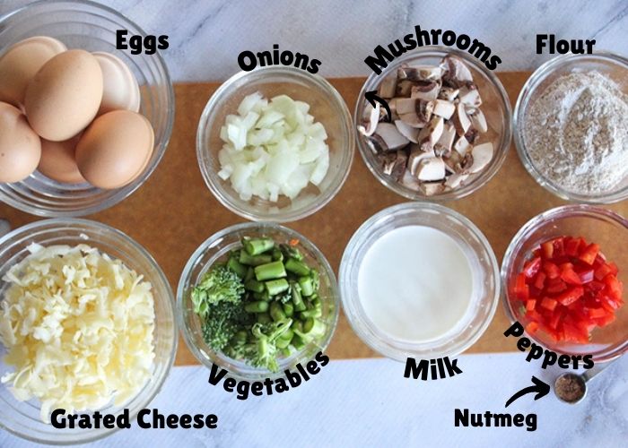 Ingredients fro the breakfast pie: shredded cheese, eggs, vegetables, onions, mushrooms, milk, peppers and flour