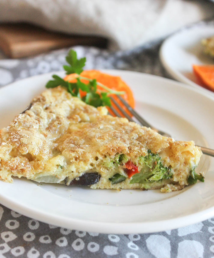 A slice of vegetable breakfast pie on a plate