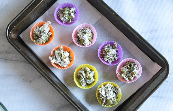 coconut clusters ingredients in cups on a baking sheet ready to bake