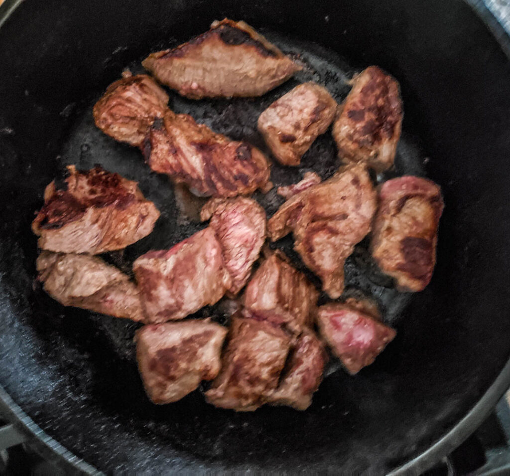 Beef stew cooking in a skillet