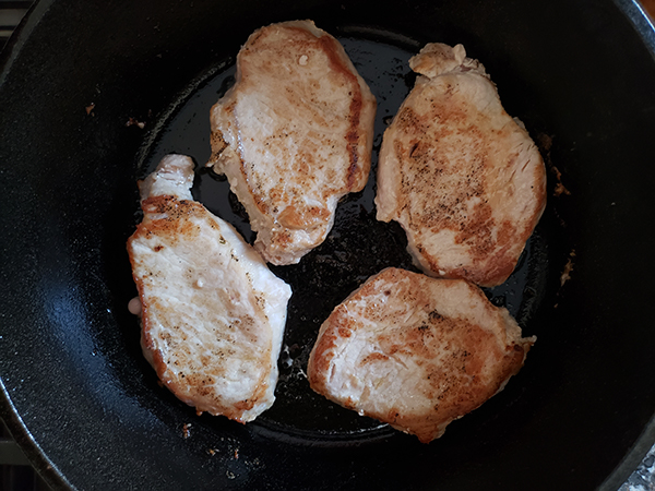 browned pork chops in a skillet