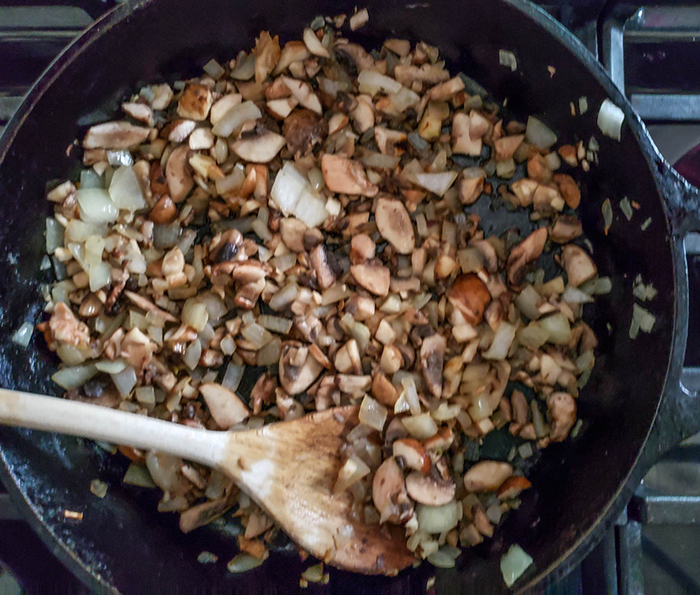 onions and mushrooms cooking in a skillet