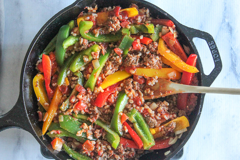 process step 4 overhead view of unstuffed peppers in a pan