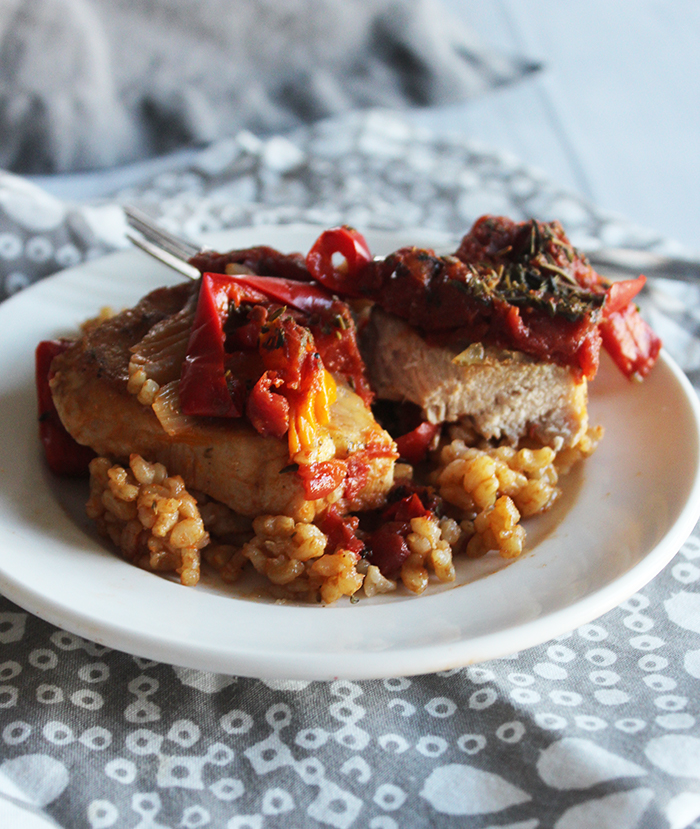 a pork chop on a plate cut in half on top of rice