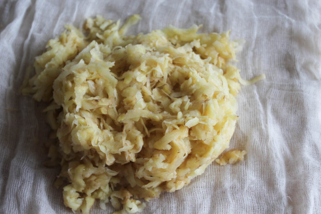 Shredded potatoes on cheesecloth