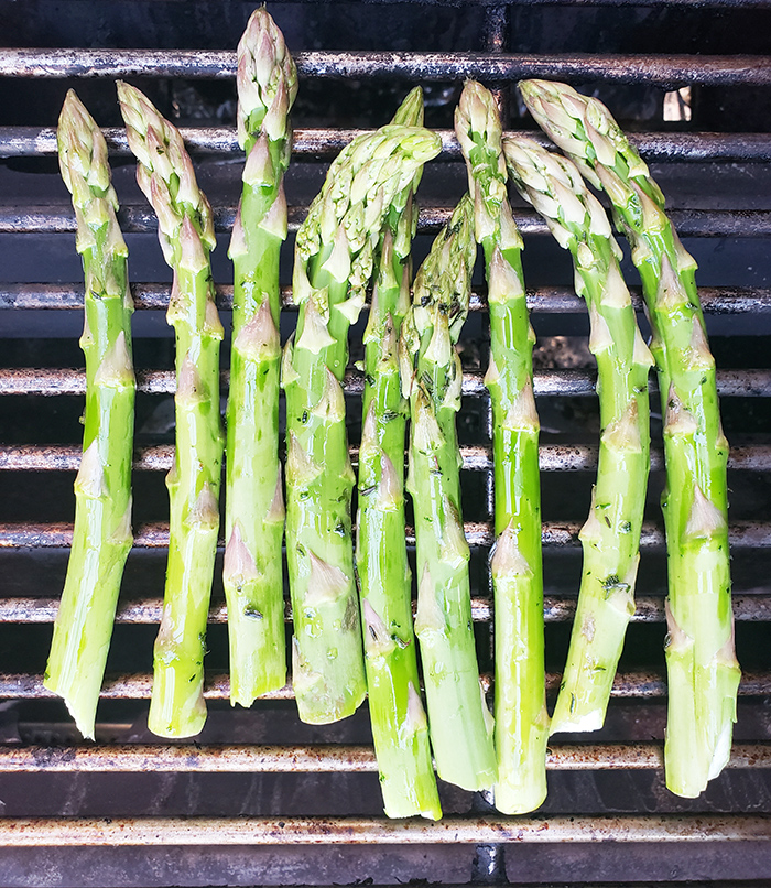 This image is asparagus on the grill. Nine pieces are on the grill rack.