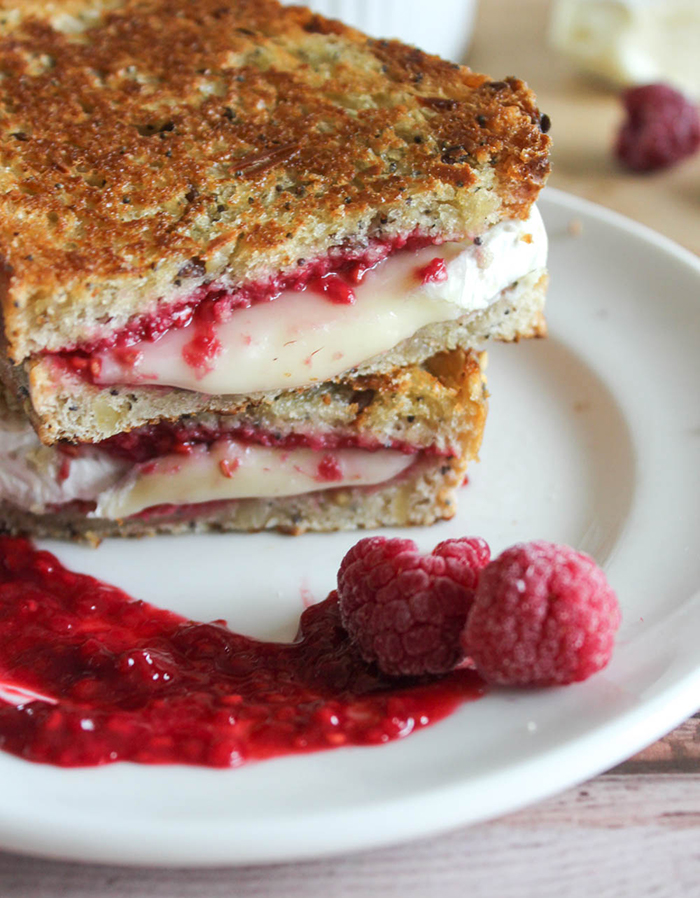 grilled brie cheese with raspberries sandwich on a plate