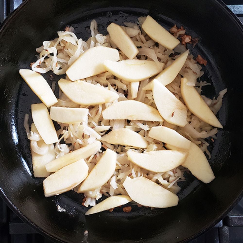 Process step 3, sauerkraut in a skille with apple slices on top