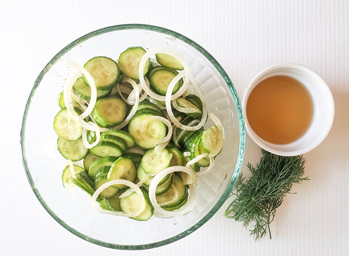 Cucumber slices and onions mixed together ina bowl