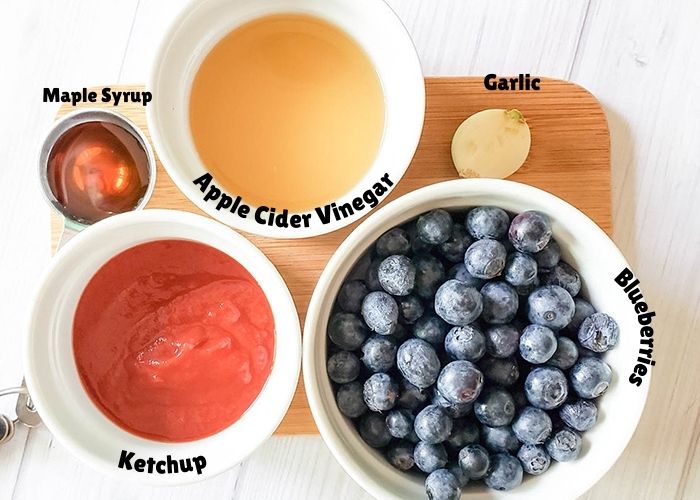 the ingredients on a cutting board, ketchup, maple syrup, Apple Cider Vinegar, garlic, blueberries