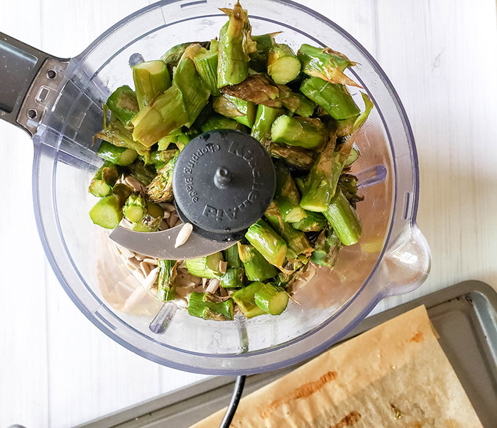 chopped asparagus garlic and sunflower seeds in a food processor