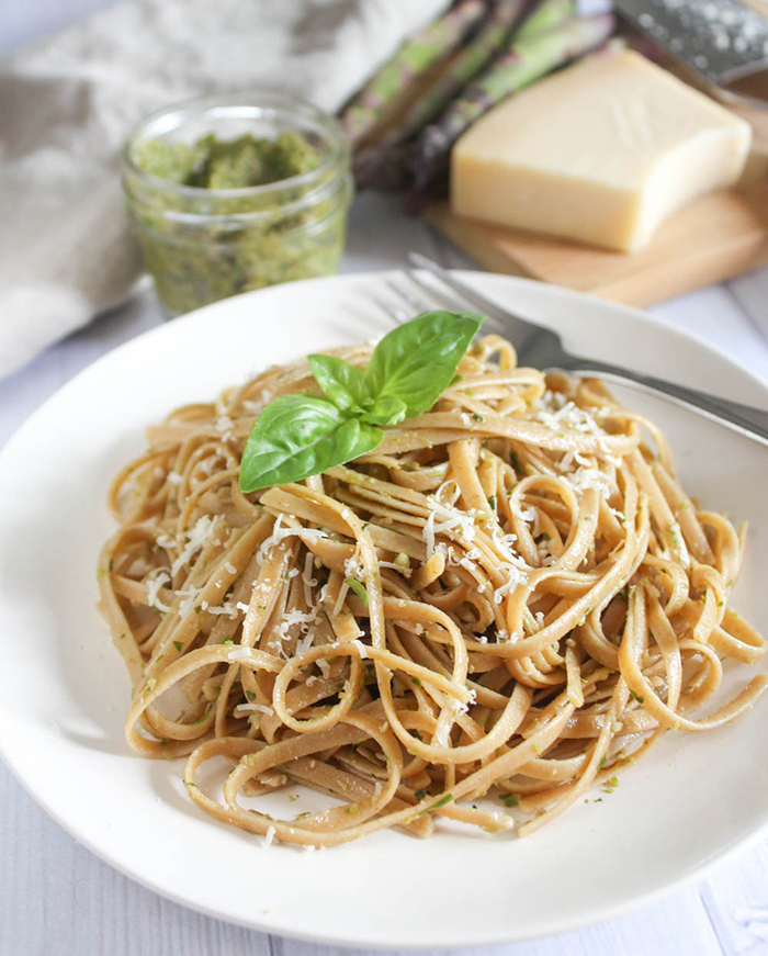 Asparagus pesto on top of linguine pasta with shredded cheese and basil on top