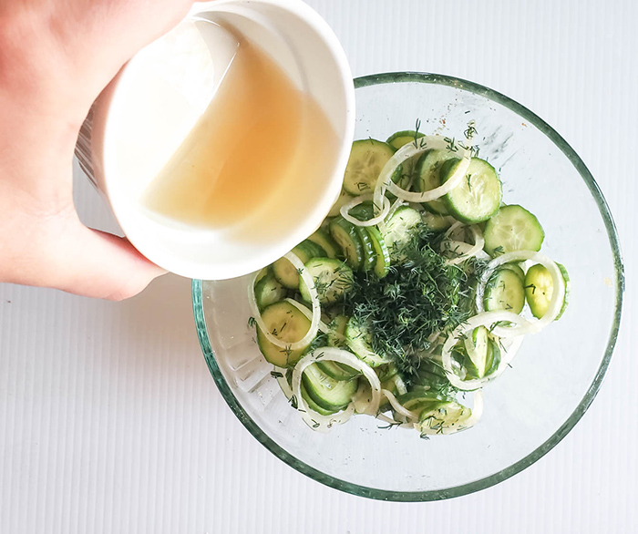 vinegar pouring into the cucumbers