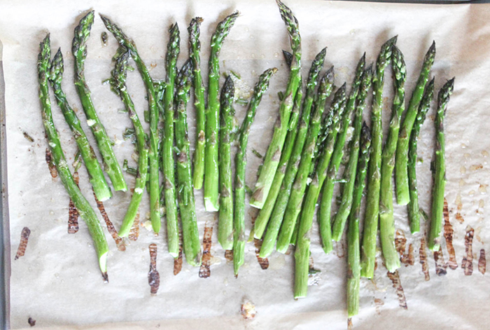 A view of fully roasted asparagus on parchment paper