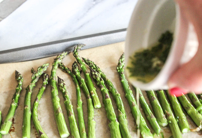 pouring the melted butter over the asparagus