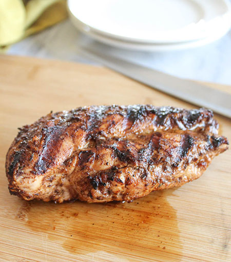 a grilled chicken breast on a cutting board 