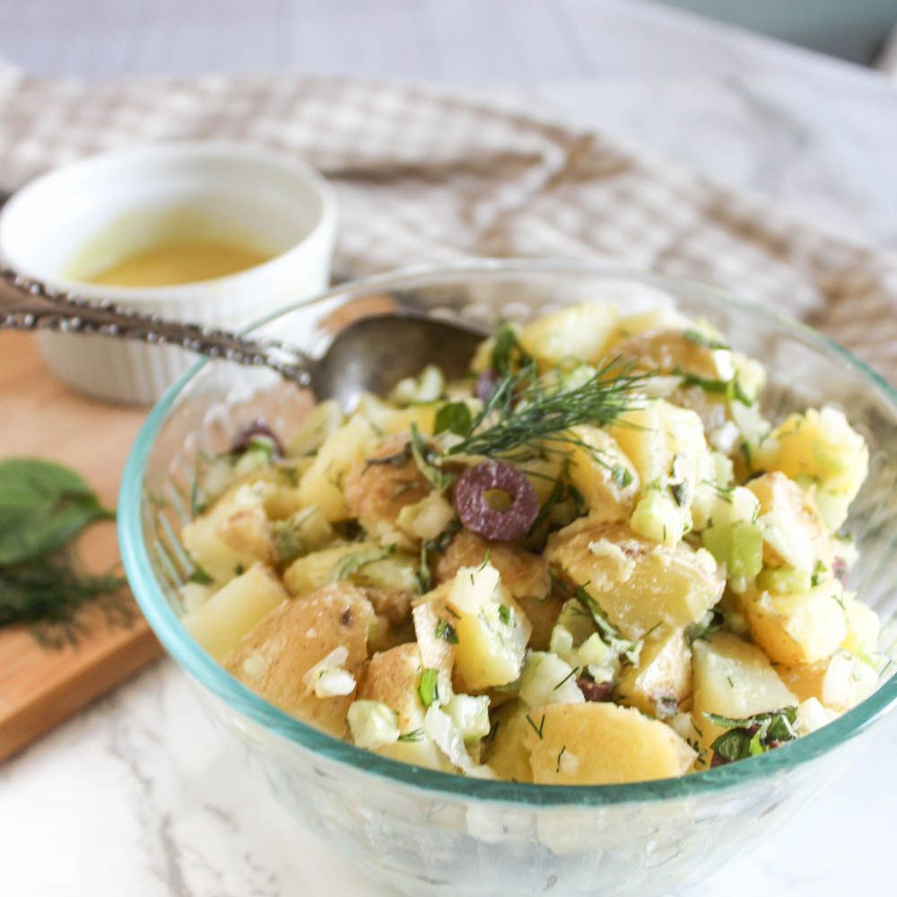 a bowl of potato salad in a bowl with a spoon