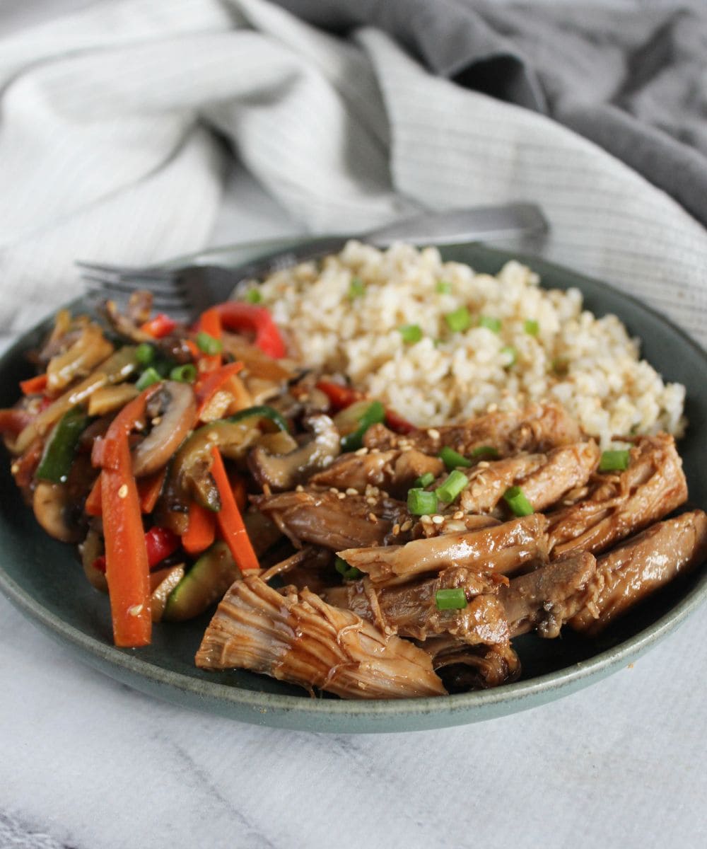 slow cooker asian pork plated with vegetables and rice