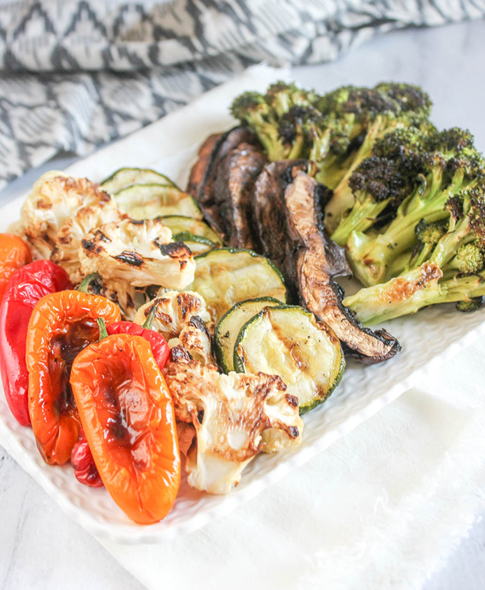 A plate of assorted grilled vegetables: peppers, cauliflower, zucchini, mushrooms and broccoli