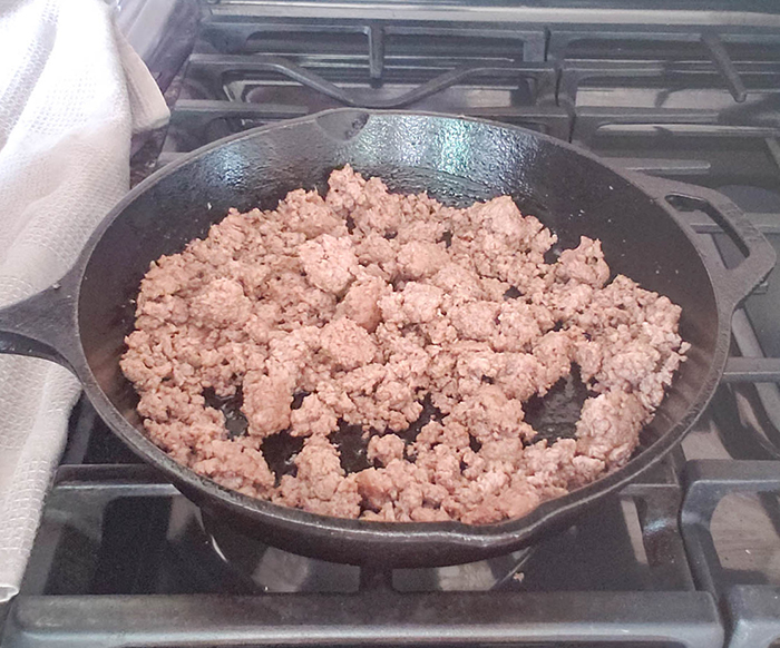 A picture of ground beef cooking in a skillet